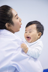 Doctor happy to little boy.medicine, healtcare, pediatry and people concept - happy doctor or pediatrician holding baby.