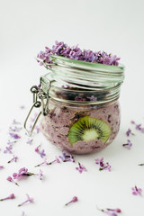 healthy violet smoothie breakfast in a glass jar with lilac flowers