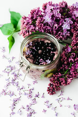 healthy violet smoothie breakfast in a glass jar with lilac flowers