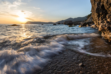 large stones in the sea at sunset