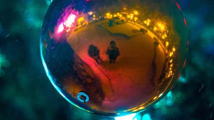 Reflection of people in the Christmas tree toy