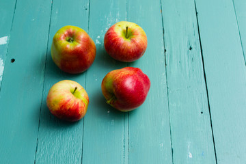 four apples on blue wooden background