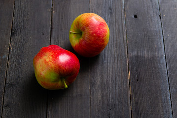 two apples on black wooden background