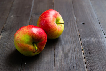 two apples on black wooden background
