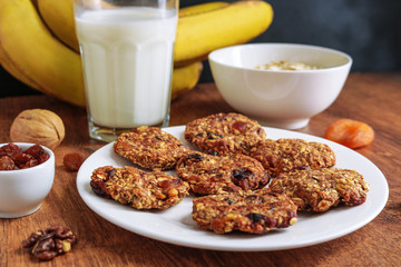 healthy food. homemade oat flakes cookies chips on plate bananas glass of milk and ingredients close up