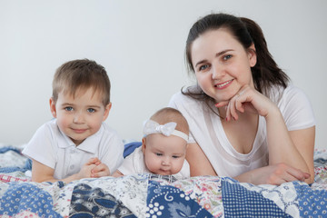 Mother, baby daughter and boy son communicate and have fun.