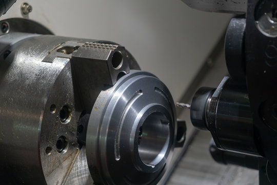The CNC lathe machine milling the slot with on the metal disk parts .The CNC turn-mill machine making the automotive parts with flat endmill tools.