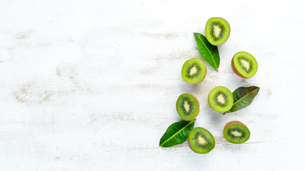 Fresh kiwi on a white wooden table. Rustic style. Fruits. Top view. Free space for text.