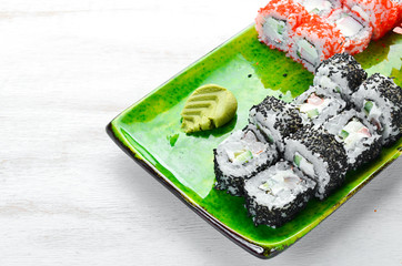 Sushi and maki rolls on a plate. Top view. Free space for your text. On a white background.