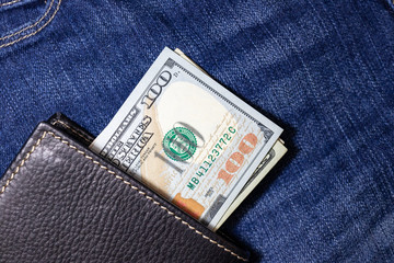 USA money, US DOLLAR, US Banknote inside black leather wallet on Jean Background.