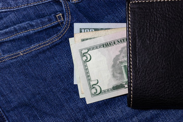 USA money, US DOLLAR, US Banknote inside black leather wallet on Jean Background.