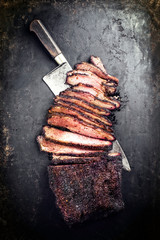Traditional smoked barbecue wagyu beef brisket offered as top view with a knife on an old rustic...
