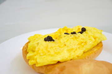 Scrambled eggs, black truffles, sauce, bread, close up