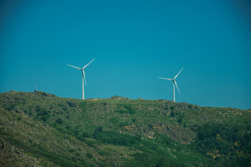 Wind turbines for electric power generation over hill