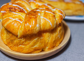 Bread on a wooden tray.Lightly burnt toast.It has a white sweet sauce on it.Close-up shot of toast, color makes people want to eat.