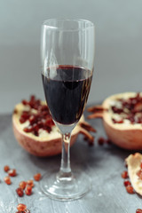 A wine glass with red wine stands on a gray grunge background next to grenades.