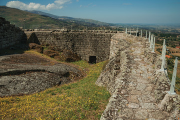 Pathway over stone wall around flowered courtyard