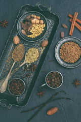 Spices for baking gingerbread, muffins or mulled wine - vanilla, cinnamon, coriander, cloves cardamom fennel nutmeg on grey background