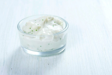 lavender cream in glass pot on white wooden table background