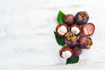 Obraz premium Tropical fruits, Mangosteen on a white wooden background. Top view. Free space for text.