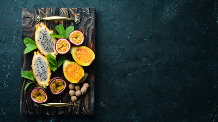 Tropical Fruits - Cactus and dragon fruit on a wooden background. Top view. Free space for text.