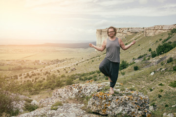 Obraz premium Yoga practice. A man is resting in the mountains.