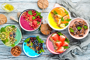 A healthy breakfast. Colorful fruit smoothies with yogurt, fresh fruit and berries. Top view. Free space for your text. On a white background.