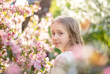 Fototapeta premium candid portrait of a girl in a blooming apple orchard