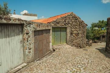 Fototapeta na wymiar House with iron garage gate on cobblestone alley