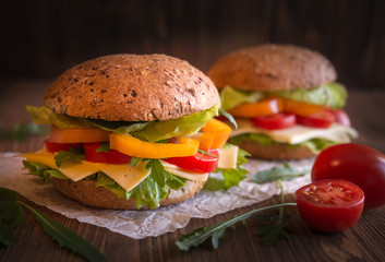 Delicious andwiches with cheese, lettuce, vegetables and arugola on dark background