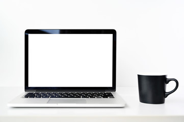 blank screen Modern laptop computer with black coffee cup on table in office view backgrounds
