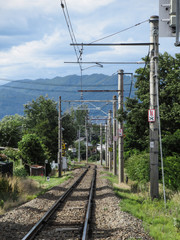 単線の線路と夏の山並み