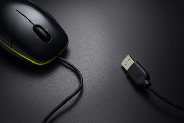 Black wired mouse on the dark office desk