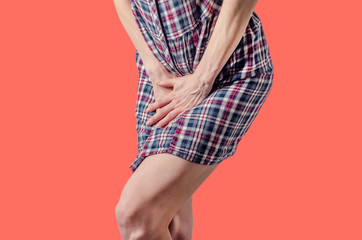 Young woman pressed her hands to the lower abdomen. Medical concept. Gynecological problems