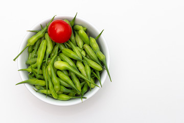 Bowl of radish seed pods with cherry tomato on a white background.