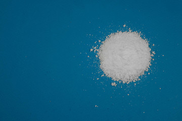 Obraz na płótnie Canvas a mountain of white powder on a blue background