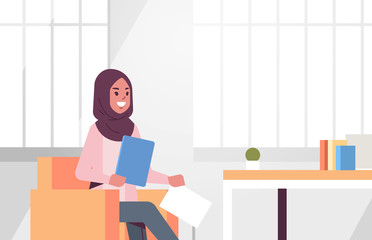 arabic businesswoman sitting at workplace desk arab business woman holding paper documents preparing report working process concept modern office interior flat portrait horizontal
