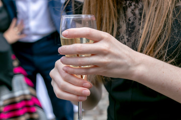 woman's hand holding glass of wine to celebrated wedding ceremony. 