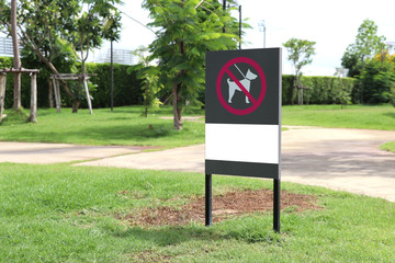The sign indicates that dogs are not allowed in this area. Signs forbidding dogs from entering the park.