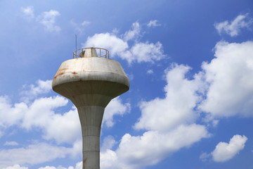 Water tower with clouds and blue sky background. © Narin