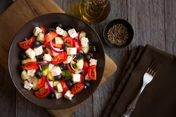 Fotobehang Delicious greek salad with feta cheese and olives in a brown plate © Maresol