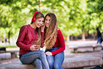 Smiling teenagers listening music together from phone