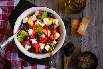 Delicious greek salad with feta cheese and olives in a white bowl