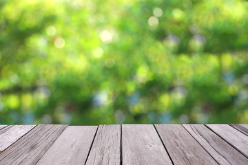 Naklejka na ściany i meble Wooden old plank with blurred greenery background.