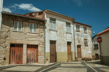 Shabby old houses with wooden doors on empty alley