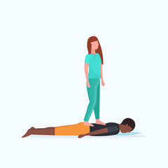 masseuse in uniform standing on patient's back doing healing treatment african american guy having massage manual therapy concept full length