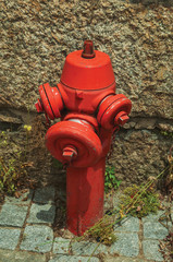 Fototapeta na wymiar Red hydrant on a paved alley
