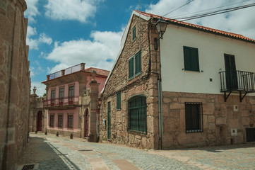 Old house with stone wall on deserted alley