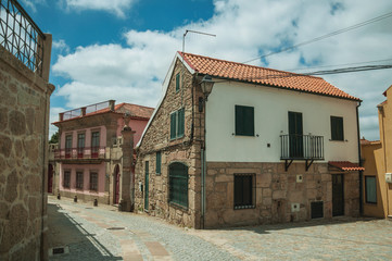 Old house with stone wall on deserted alley
