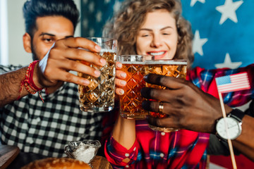 Cheering. Focus at glasses with beer in pub.